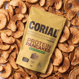 Embalagem CORIAL Protein Pancakes Maçã e Canela sobre fatias de maçã desidratada com canela